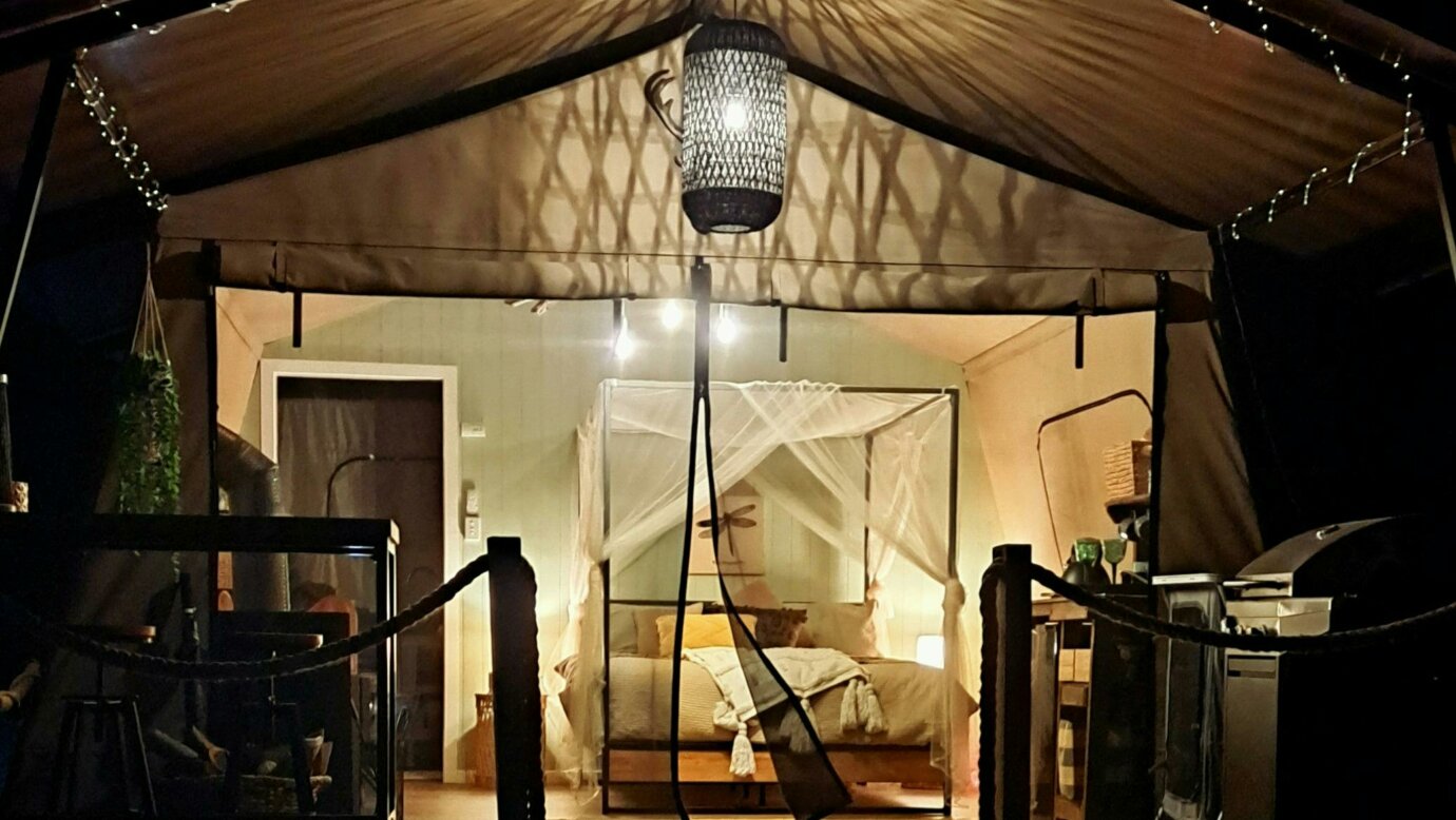a luxury safari tent lit up at night