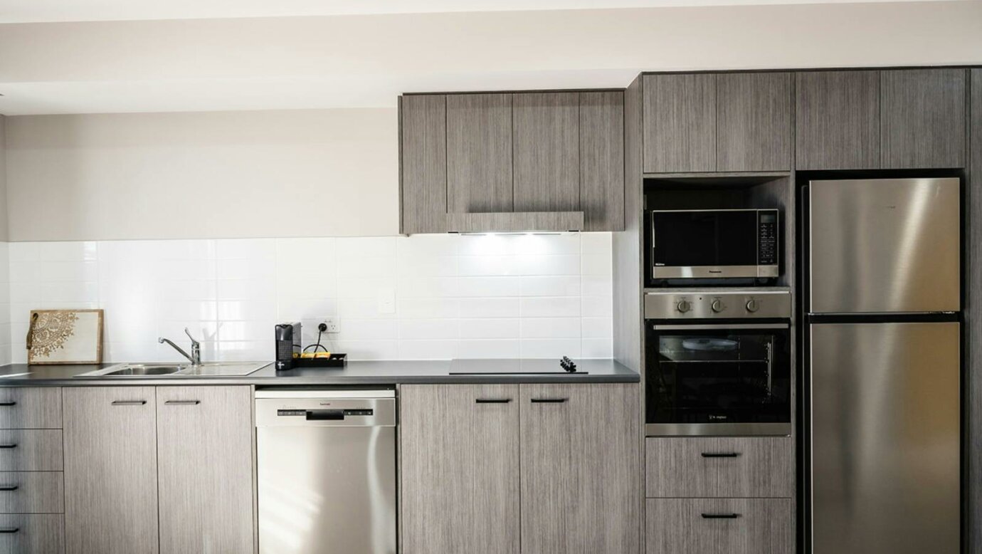 Image of kitchen including a fridge, dishwasher and sink