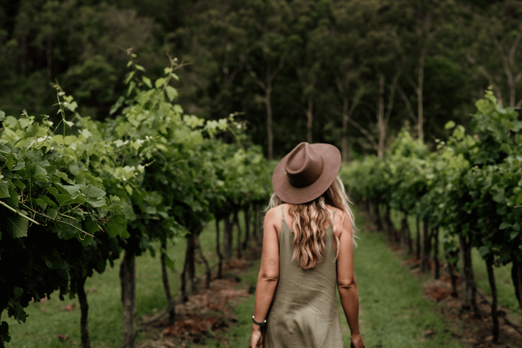 A young woman strolls through a wineries vineyard