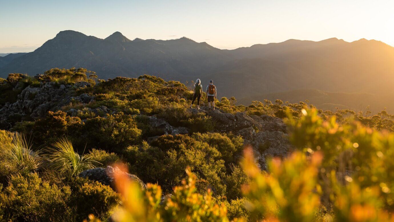 Hikers admiring the surrounding mountains from the top of Mount Maroon in the Scenic Rim, Queensland, Australia