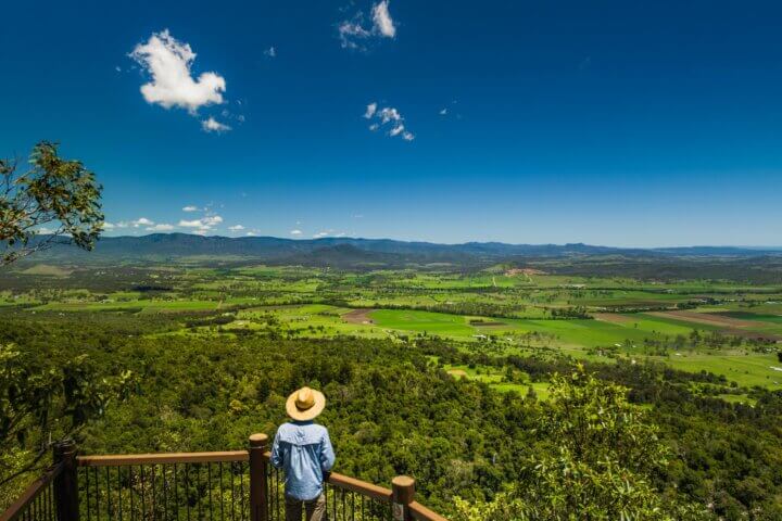 A man stands at a lookout on the side of Mount French in the Scenic Rim region in south-east Queensland, Australia