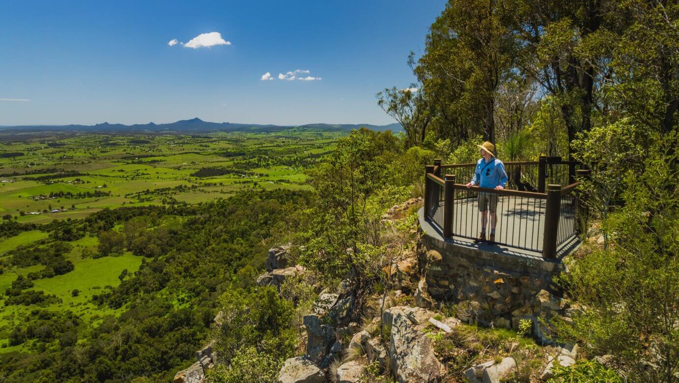 A man stands at a lookout on the side of Mount French in the Scenic Rim region in south-east Queensland, Australia