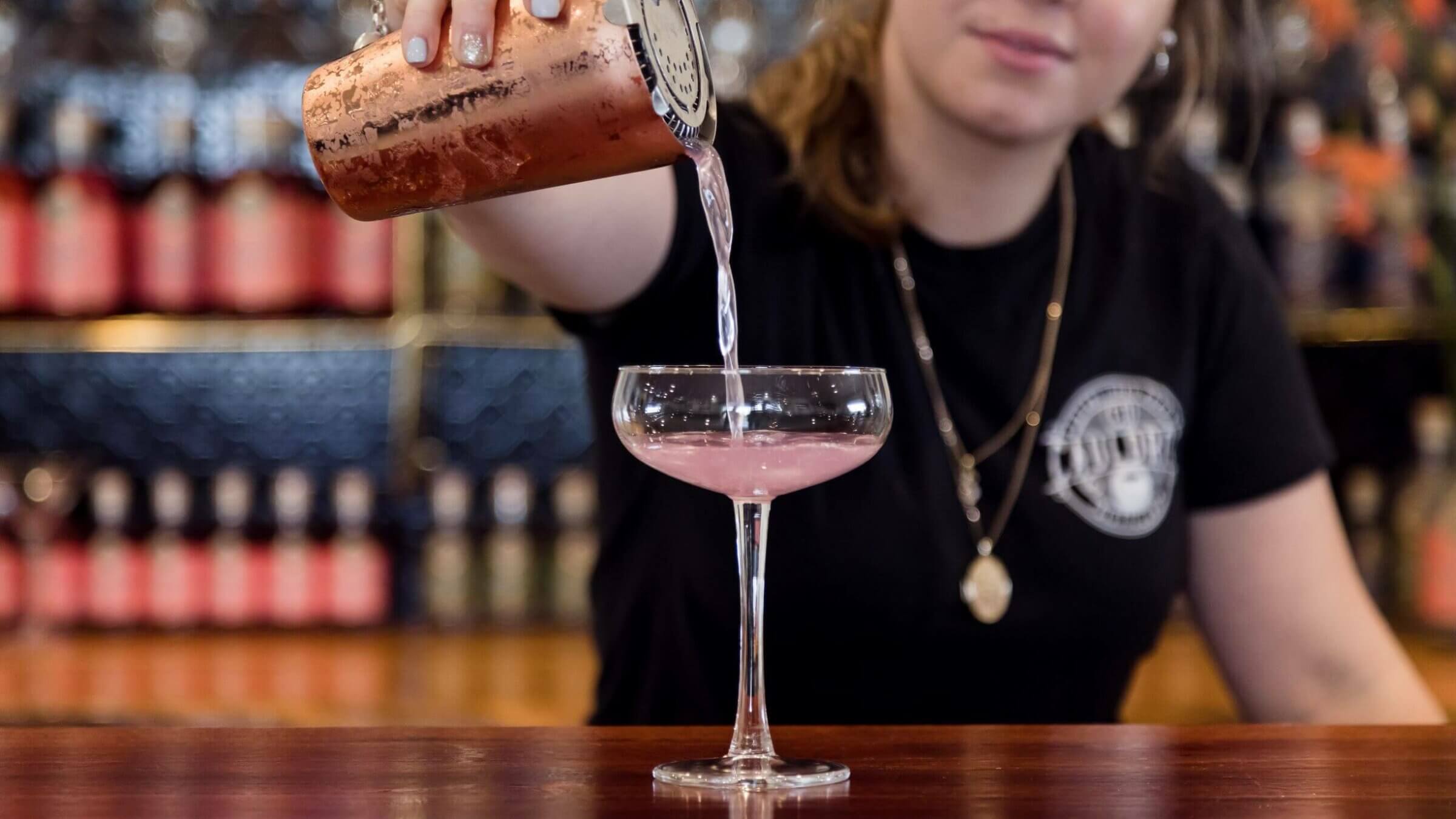 Lady pouring pink cocktail at a bar, Cauldron Estate Distillery, Tamborine Mountain, Scenic Rim, Queensland.