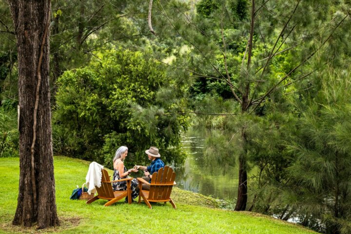 Couple relaxing beside tranquil Canungra Creek