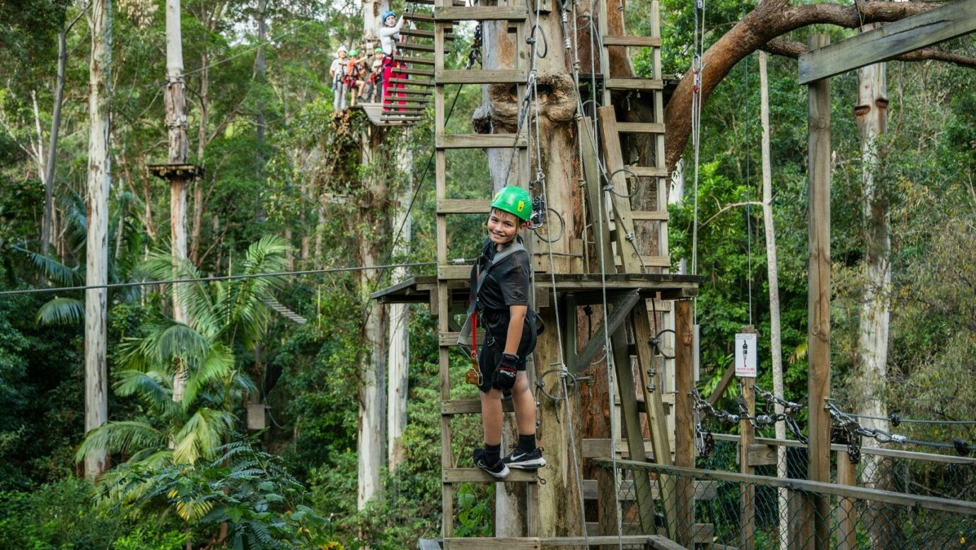 Kids 8 and older can climb on the course. Kid climbing down a ladder