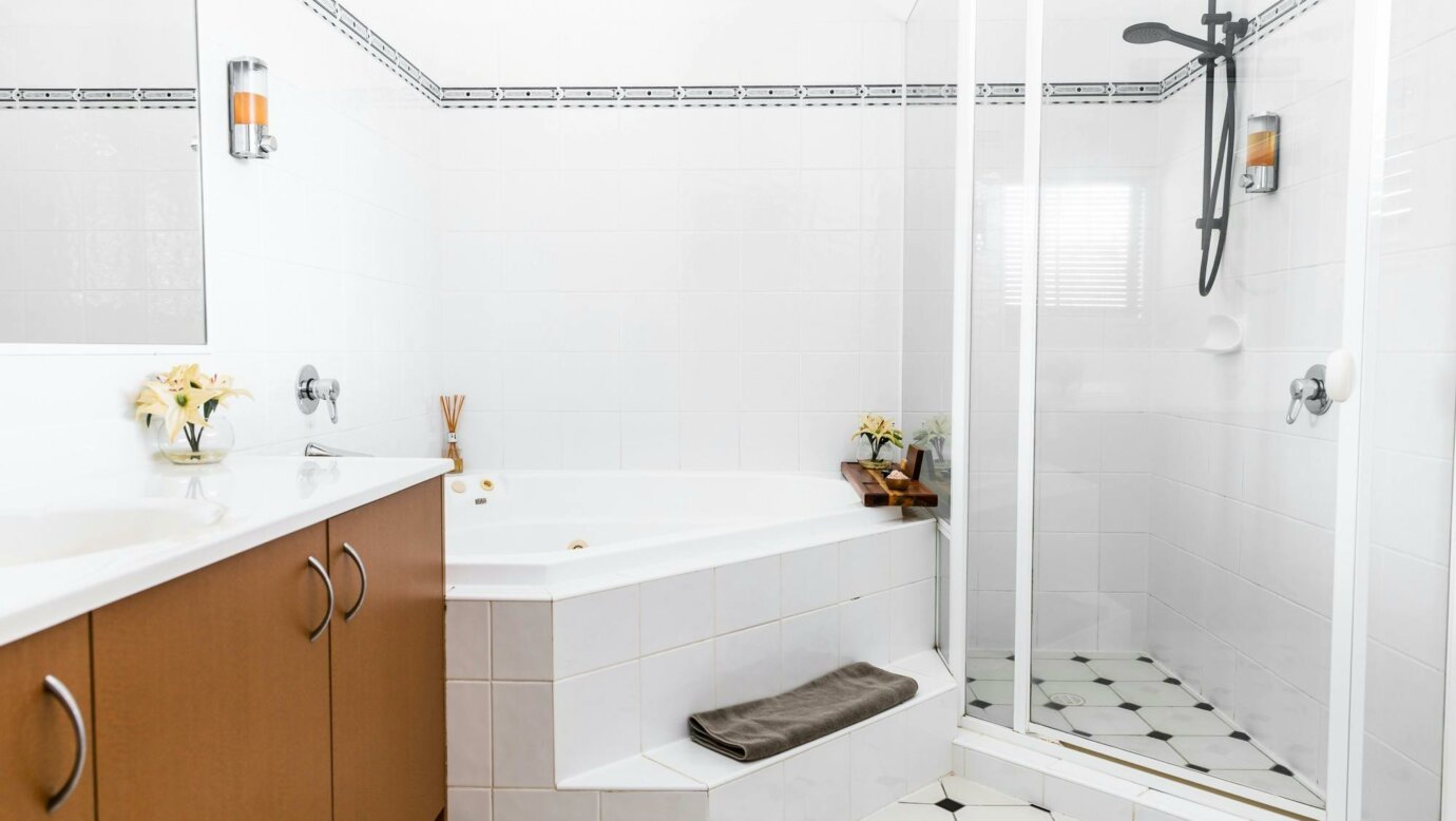 Double person spa in white bathroom with seperate shower and tiled floor